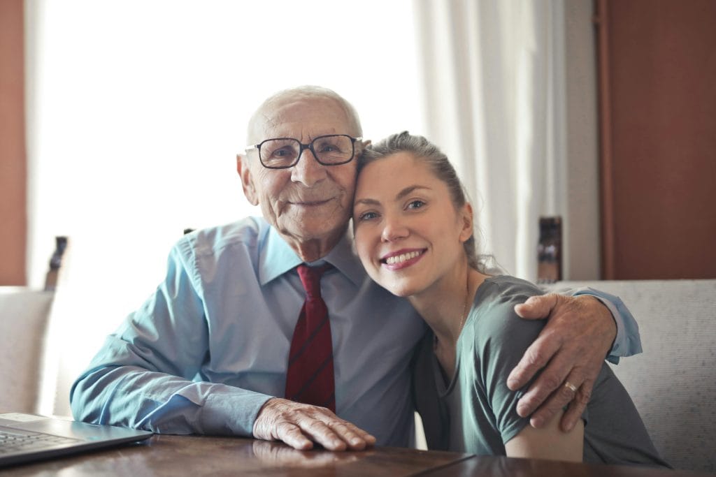 Grandfather with tie hugging granddaughter