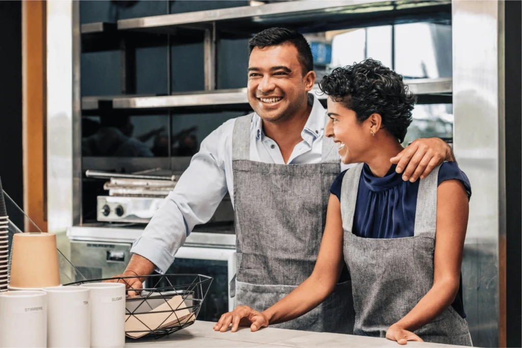 Two business owners smiling in kitchen