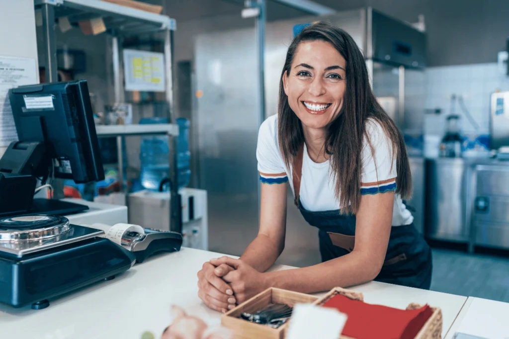 Business owner smiling at store front