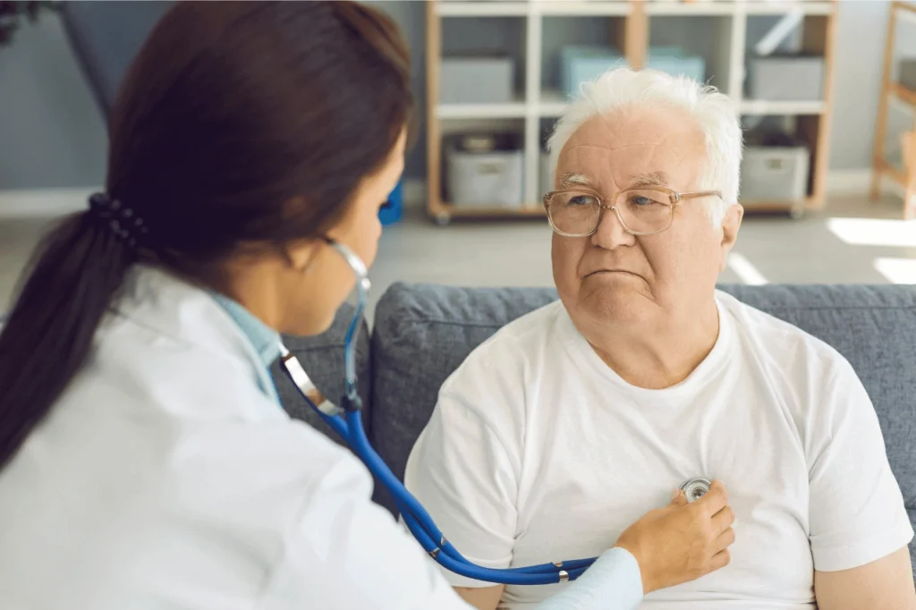 Doctor checking heartbeat on older man